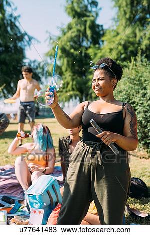 Friends blowing bubbles in park View Large Photo Image Stock Image - Friends blowing bubbles in park. Fotosearch