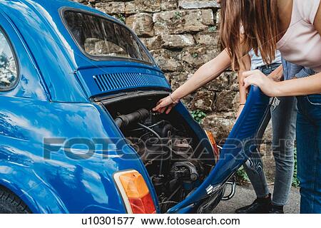 Friends fixing stalled car in countryside View Large Photo Image Stock Photo - Friends fixing stalled car in countryside. Fotosearch