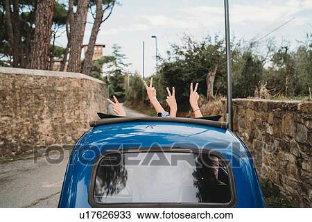 Friends gesturing peace sign in car sunroof, Florence, Toscana, Italy View Large Photo Image Stock Image - Friends gesturing peace sign in car sunroof, Florence, Toscana, Italy. Fotosearch
