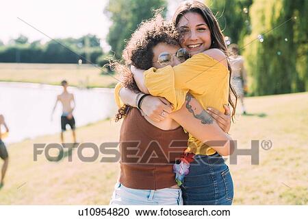 Friends hugging in park View Large Photo Image Stock Image - Friends hugging in park. Fotosearch