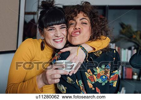 Stock Image - Friends laughing and making faces. Fotosearch