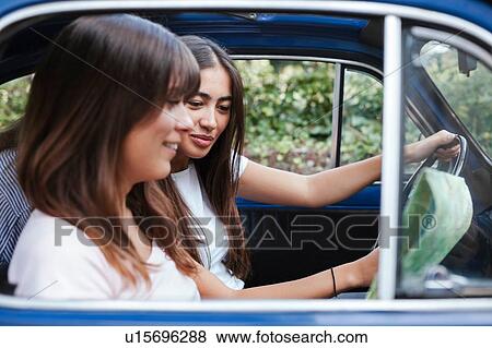 Friends reading route map inside car View Large Photo Image Stock Photo - Friends reading route map inside car. Fotosearch