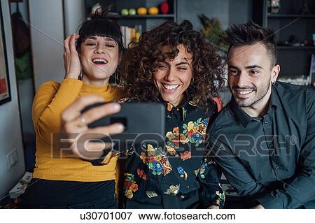 Friends taking selfie at home View Large Photo Image Stock Photo - Friends taking selfie at home. Fotosearch