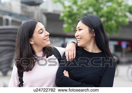 Friends talking and walking in city View Large Photo Image Stock Image - Friends talking and walking in city. Fotosearch