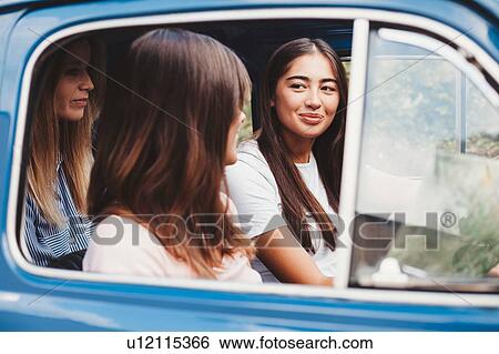 Stock Photograph - Friends talking inside car. Fotosearch