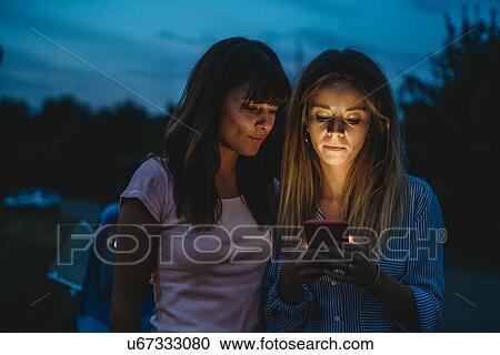 Friends using smartphone in countryside View Large Photo Image Stock Image - Friends using smartphone in countryside. Fotosearch