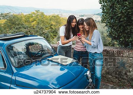 Picture - Friends using smartphone in countryside, Florence, Toscana, Italy. Fotosearch