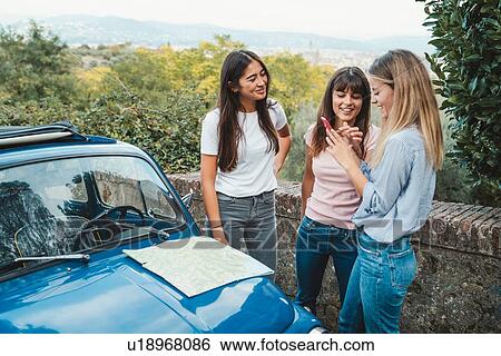 Stock Photograph - Friends using smartphone in countryside, Florence, Toscana, Italy. Fotosearch