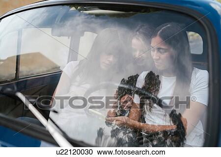 Friends using smartphone inside car View Large Photo Image Stock Image - Friends using smartphone inside car. Fotosearch