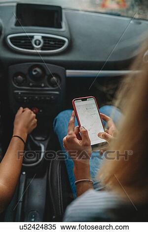 Friends using smartphone inside car View Large Photo Image Stock Photography - Friends using smartphone inside car. Fotosearch