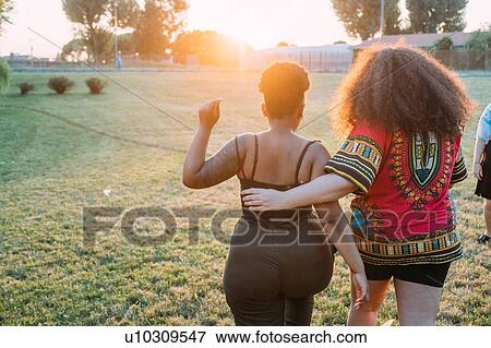 Friends walking in park View Large Photo Image Stock Photo - Friends walking in park. Fotosearch
