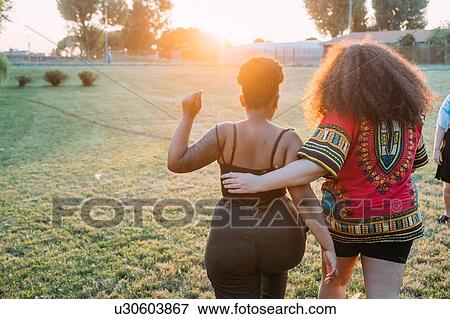 Friends walking in park View Large Photo Image Stock Photo - Friends walking in park. Fotosearch