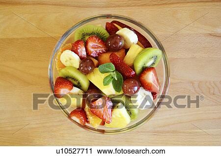 Stock Image - Fruit salad in bowl, studio shot.. Fotosearch