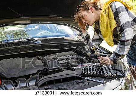 Frustrated woman repairing car View Large Photo Image Stock Image - Frustrated woman repairing car. Fotosearch