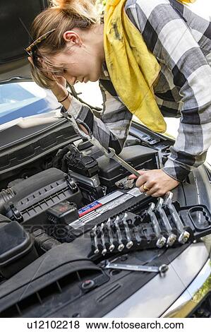 Frustrated woman repairing car View Large Photo Image Stock Photo - Frustrated woman repairing car. Fotosearch
