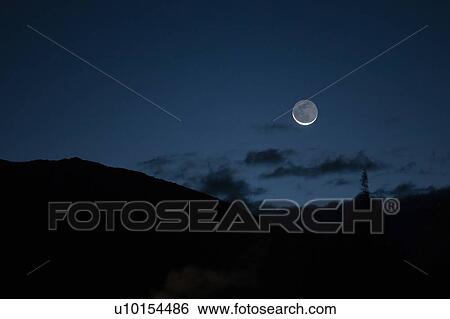 Stock Photograph - Full moon above mountains. Fotosearch