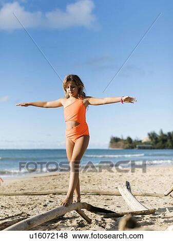 Girl balancing on driftwood View Large Photo Image Stock Photo - Girl balancing on driftwood. Fotosearch