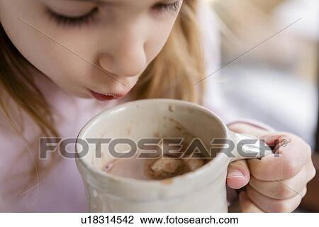 Girl blowing on hot chocolate View Large Photo Image Stock Image - Girl blowing on hot chocolate. Fotosearch