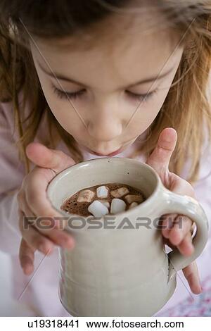 Girl blowing on hot chocolate View Large Photo Image Stock Image - Girl blowing on hot chocolate. Fotosearch