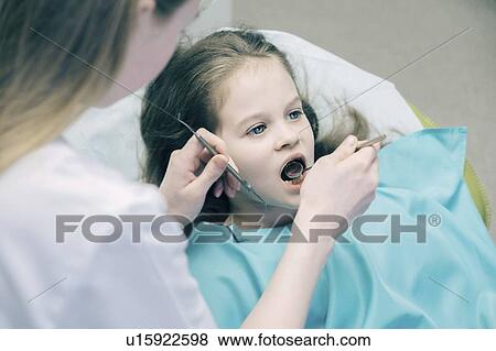 Stock Photo - Girl during dentist examination. Fotosearch