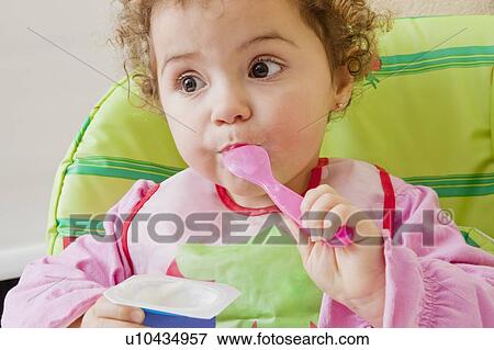 Girl eating yoghurt View Large Photo Image Stock Photo - Girl eating yoghurt. Fotosearch