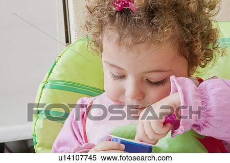 Stock Photography - Girl eating yoghurt. Fotosearch