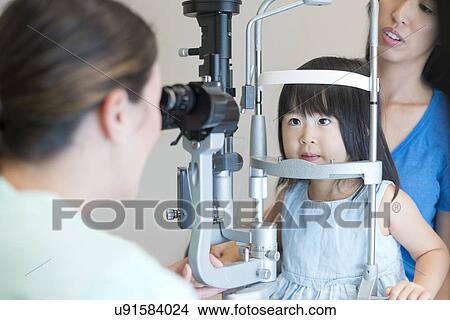 Girl having her eyes tested. View Large Photo Image Picture - Girl having her eyes tested.. Fotosearch