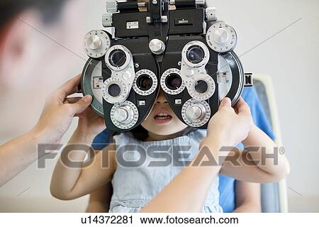 Girl having her eyes tested. View Large Photo Image Stock Image - Girl having her eyes tested.. Fotosearch