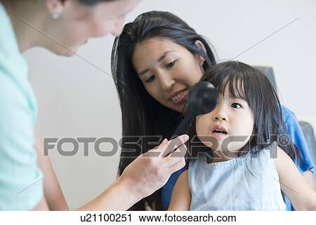 Stock Image - Girl having her eyes tested.. Fotosearch