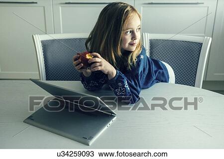 Girl leaning on table by laptop View Large Photo Image Stock Image - Girl leaning on table by laptop. Fotosearch
