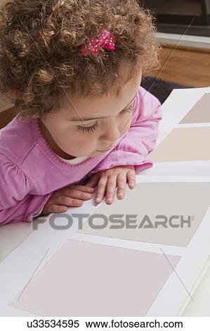 Stock Photography - Girl looking at paint swatches. Fotosearch