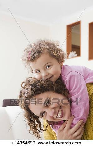 Girl on her mother's back View Large Photo Image Stock Photo - Girl on her mother's back. Fotosearch