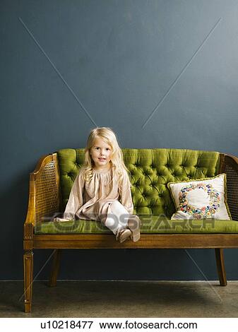Girl sitting on green sofa View Large Photo Image Stock Photo - Girl sitting on green sofa. Fotosearch