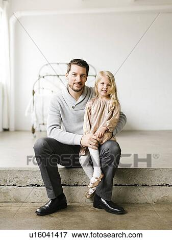 Stock Photo - Girl sitting on her father's lap. Fotosearch