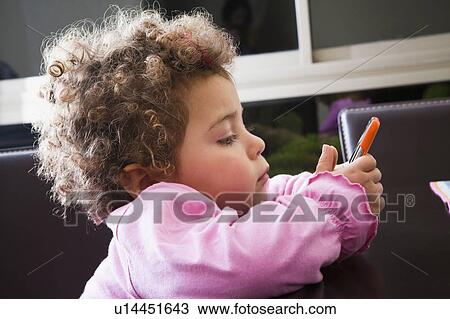 Stock Image - Girl with curly brown hair holding pen. Fotosearch