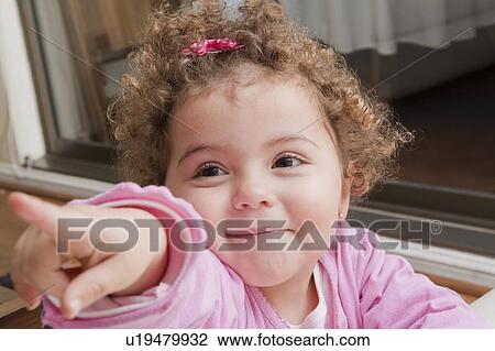 Girl with curly hair pointing View Large Photo Image Stock Image - Girl with curly hair pointing. Fotosearch