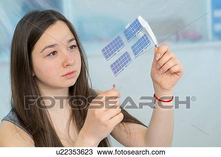 Stock Image - Girl working on electronics project.. Fotosearch