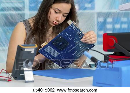 Stock Image - Girl working on electronics project.. Fotosearch