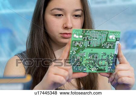 Stock Photo - Girl working on electronics project.. Fotosearch