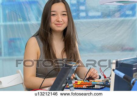 Stock Photograph - Girl working on electronics project.. Fotosearch