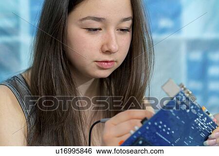 Stock Photograph - Girl working on electronics project.. Fotosearch