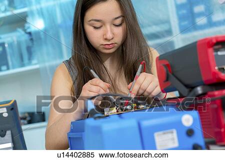 Stock Photography - Girl working on electronics project.. Fotosearch