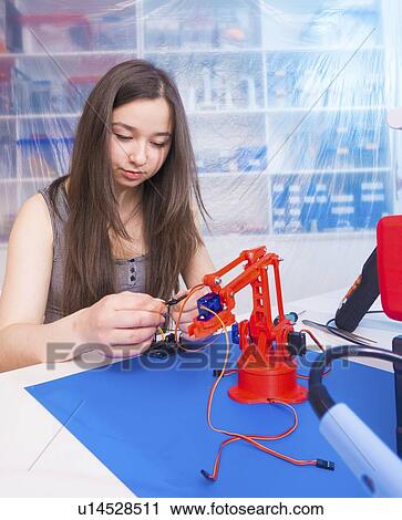 Stock Image - Girl working on robotics project.. Fotosearch