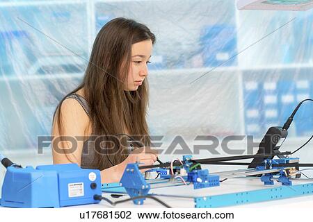 Stock Image - Girl working on robotics project.. Fotosearch