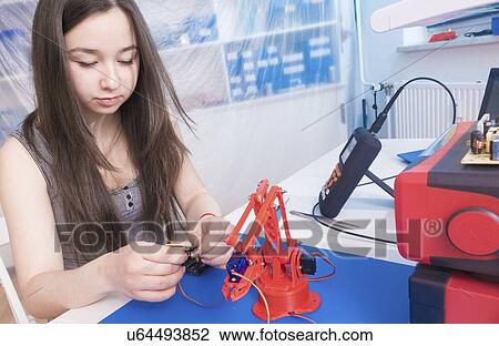 Stock Image - Girl working on robotics project.. Fotosearch