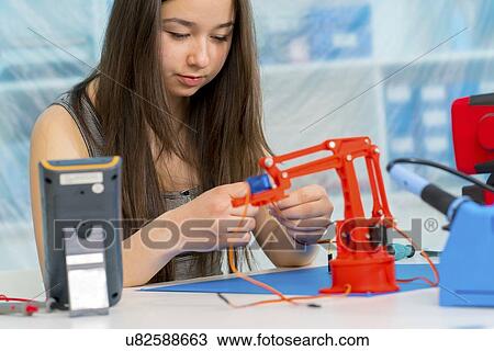 Stock Image - Girl working on robotics project.. Fotosearch
