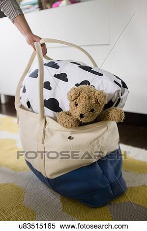 Girl's hand holding bag with blanket and teddy bear View Large Photo Image Stock Photography - Girl's hand holding bag with blanket and teddy bear. Fotosearch