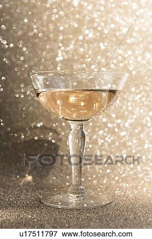 Glass of champagne against glitter background View Large Photo Image Stock Photo - Glass of champagne against glitter background. Fotosearch