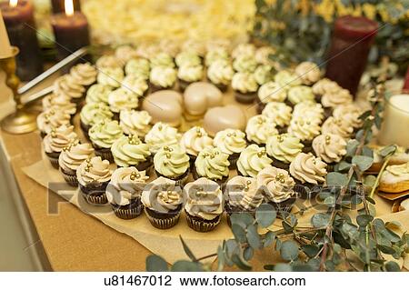 Stock Image - Green and pink cupcakes in circle. Fotosearch