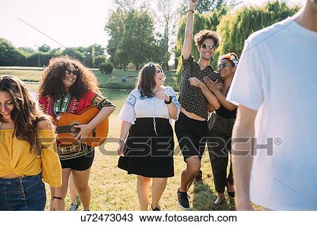 Group of friends dancing, playing guitar in park View Large Photo Image Stock Image - Group of friends dancing, playing guitar in park. Fotosearch